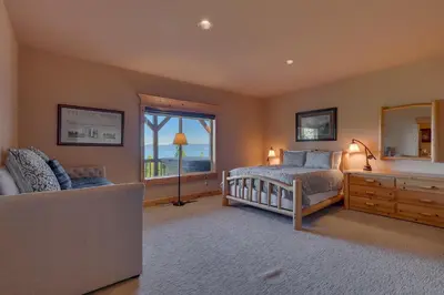 a bedroom with a bed and a window and a couch at Crystal Lakeview Lodge by Tahoe Getaways - Private Hot Tub, Foosball Table & Tahoe Park HOA in Tahoe City