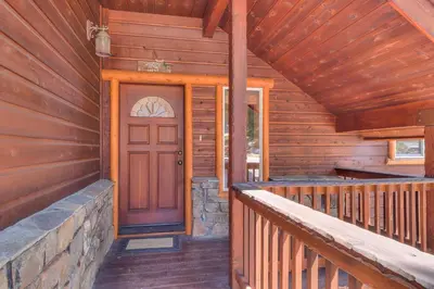 a front door of a wooden cabin with a porch at Crystal Lakeview Lodge by Tahoe Getaways - Private Hot Tub, Foosball Table & Tahoe Park HOA in Tahoe City