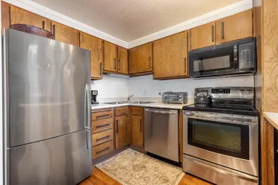 a kitchen with stainless steel appliances and wooden cabinets at Epic Condo walk to Canyon Lodge in Mammoth Lakes