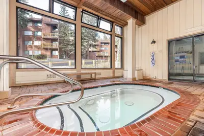 a hot tub in a room with windows at Epic Condo walk to Canyon Lodge in Mammoth Lakes