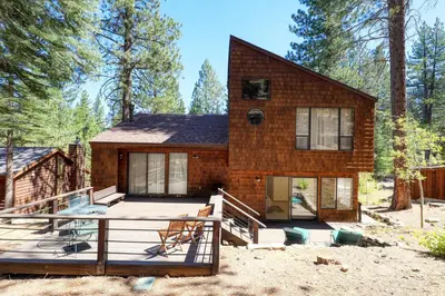 a house in the woods with a large deck at Basque Lodge at Northstar by Tahoe Getaways - Pet-Friendly 5BR w Free Shuttle & HOA Amenities in Truckee