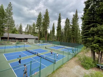 a group of people playing tennis on tennis courts at Basque Lodge at Northstar by Tahoe Getaways - Pet-Friendly 5BR w Free Shuttle & HOA Amenities in Truckee