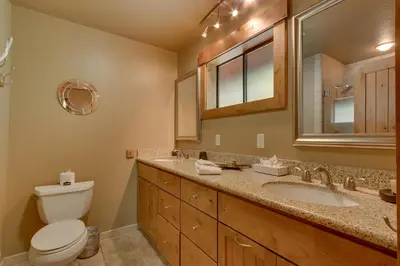 a bathroom with a toilet and a sink and a mirror at Club 151 at Dollar Point by Tahoe Getaways - Pet-Friendly 4BR w Hot Tub & Fenced Yard in Tahoe City