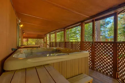 a bath tub sitting in a room with windows at Club 151 at Dollar Point by Tahoe Getaways - Pet-Friendly 4BR w Hot Tub & Fenced Yard in Tahoe City