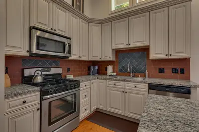 a kitchen with white cabinets and stainless steel appliances at Glades Getaway by Tahoe Getaways - Charming Pet-Friendly 3 BD North Shore Cabin w Wood Fireplace & Short Drive to Ski Resorts in Carnelian Bay