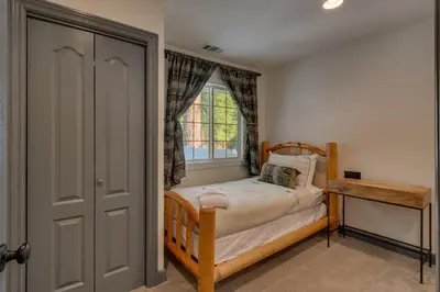 a small bedroom with a bed and a window at Glades Getaway by Tahoe Getaways - Charming Pet-Friendly 3 BD North Shore Cabin w Wood Fireplace & Short Drive to Ski Resorts in Carnelian Bay