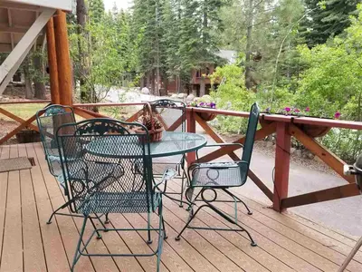 three chairs and a table on a deck at Glades Getaway by Tahoe Getaways - Charming Pet-Friendly 3 BD North Shore Cabin w Wood Fireplace & Short Drive to Ski Resorts in Carnelian Bay