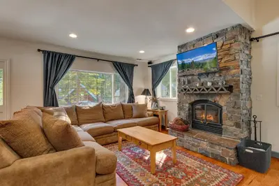 a living room with a couch and a fireplace at Glades Getaway by Tahoe Getaways - Charming Pet-Friendly 3 BD North Shore Cabin w Wood Fireplace & Short Drive to Ski Resorts in Carnelian Bay
