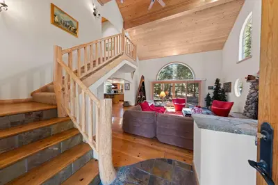 a living room with a staircase and a couch at Fox Crossing at Tahoe Donner by Tahoe Getaways - 3BR Vacation Rental w Forested Views & HOA Amenities! in Truckee