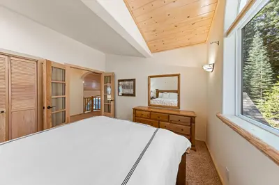 a bedroom with a bed and a large window at Fox Crossing at Tahoe Donner by Tahoe Getaways - 3BR Vacation Rental w Forested Views & HOA Amenities! in Truckee