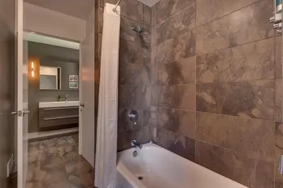 a bathroom with a tub and a sink at Mod Haus by Tahoe Getaways - Mountain Modern West Shore Home w Private Beach and Pier, Near Skiing in Homewood