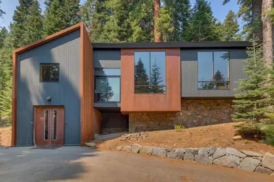 a contemporary house with glass windows and a garage at Mod Haus by Tahoe Getaways - Mountain Modern West Shore Home w Private Beach and Pier, Near Skiing in Homewood