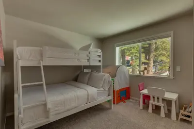 a bedroom with two bunk beds and a window at Moon Dune Chalet by Tahoe Getaways - Remodeled 3 BR Cabin plus Loft w Fenced Yard & Walk to Beach or Dining in Tahoe Vista