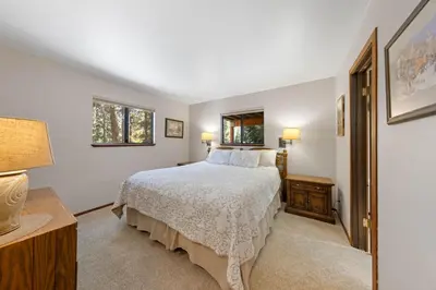 a bedroom with a bed and two windows at Nightingale Retreat by Tahoe Getaways - 3BR, Close to Tahoe City, Walk to Bike Path & Private Beach Access in Tahoe City