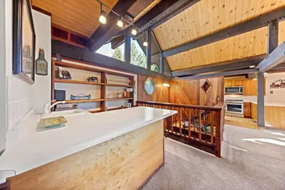 a kitchen with a large white sink and wooden walls at Nightingale Retreat by Tahoe Getaways - 3BR, Close to Tahoe City, Walk to Bike Path & Private Beach Access in Tahoe City