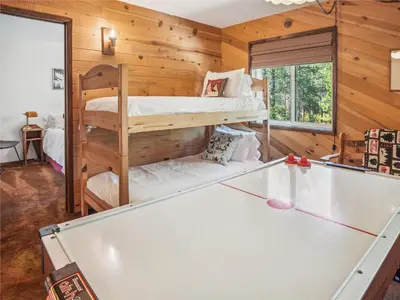 a room with a pool table and bunk beds at Rustic Retreat by Tahoe Getaways - 4BR Tahoe Donner Contemporary Cabin w Forest Views, Pet-Friendly & HOA Amenities in Truckee