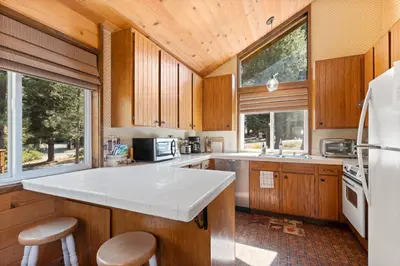 a kitchen with wooden cabinets and a white counter top at Rustic Retreat by Tahoe Getaways - 4BR Tahoe Donner Contemporary Cabin w Forest Views, Pet-Friendly & HOA Amenities in Truckee