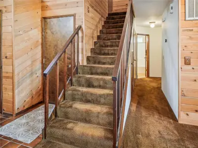 a staircase in a house with wooden walls and wooden floors at Rustic Retreat by Tahoe Getaways - 4BR Tahoe Donner Contemporary Cabin w Forest Views, Pet-Friendly & HOA Amenities in Truckee