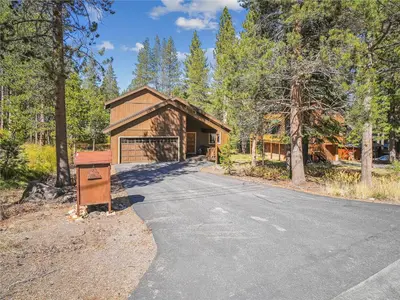 a house with a driveway leading to a garage at Rustic Retreat by Tahoe Getaways - 4BR Tahoe Donner Contemporary Cabin w Forest Views, Pet-Friendly & HOA Amenities in Truckee