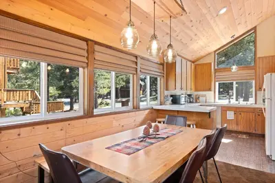 a kitchen and dining room with a wooden table and chairs at Rustic Retreat by Tahoe Getaways - 4BR Tahoe Donner Contemporary Cabin w Forest Views, Pet-Friendly & HOA Amenities in Truckee