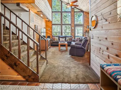 a living room with a staircase in a house at Rustic Retreat by Tahoe Getaways - 4BR Tahoe Donner Contemporary Cabin w Forest Views, Pet-Friendly & HOA Amenities in Truckee