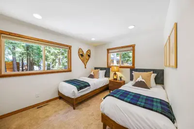 two beds in a room with two windows at Sunlit Pines by Tahoe Getaways - 2BR in Tahoe Park w Hot Tub, Fenced Yard & Pet Friendly! in Tahoe City