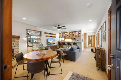 a living room with a table and a couch at Sunlit Pines by Tahoe Getaways - 2BR in Tahoe Park w Hot Tub, Fenced Yard & Pet Friendly! in Tahoe City