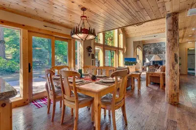 a dining room with a table and chairs at Tippy Canoe by Tahoe Getaways - 4BR West Shore w Private Hot Tub,, Sauna, EV & Walking Distance to Trailhead in Tahoma