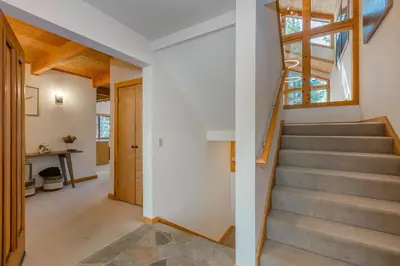a staircase in a home with white walls and wooden ceilings at Tree Haus by Tahoe Getaways - Unique Pet-Friendly Tahoe Donner Home w EV & HOA Pool & Beach in Truckee