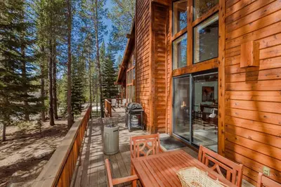 a wooden deck with benches and a grill on a cabin at Tree Haus by Tahoe Getaways - Unique Pet-Friendly Tahoe Donner Home w EV & HOA Pool & Beach in Truckee