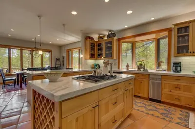 a large kitchen with wooden cabinets and a counter top at Tranquil Retreat by Tahoe Getaways - 3BR Pet-Friendly Home w Private Hot Tub, Views & HOA Amenities in Truckee