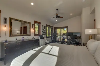 a bedroom with a white bed and a mirror at Truckee Luxe by Tahoe Getaways - 3 BR Luxury Gray's Crossing Townhome w Hot Tub on Golf Course - Close to Downtown & Northstar in Truckee