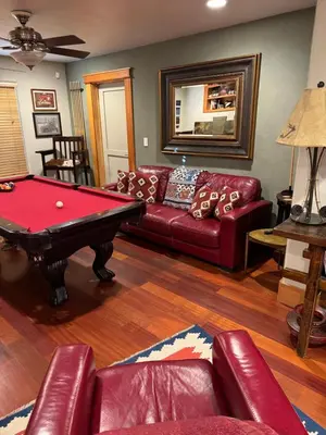 a living room with a red couch and a pool table at Lake Tahoe Luxury Guest Quarters in South Lake Tahoe