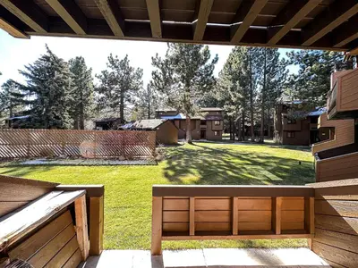 a view of a yard from a porch with a bench at Wildflower #51 condo in Mammoth Lakes