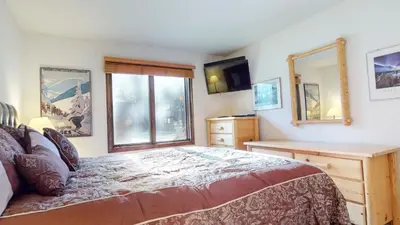 a bedroom with a large bed and a window at Wildflower #51 condo in Mammoth Lakes