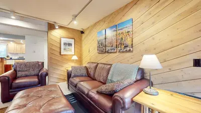 a living room with a leather couch and two chairs at Wildflower #51 condo in Mammoth Lakes