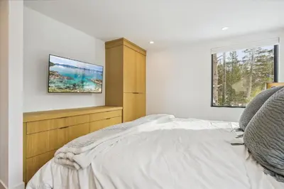 a bedroom with a bed and a tv on the wall at Diamond Run at Palisades - Luxury Townhome, Ski Shuttle Pet Friendly and Hot Tub! in Olympic Valley