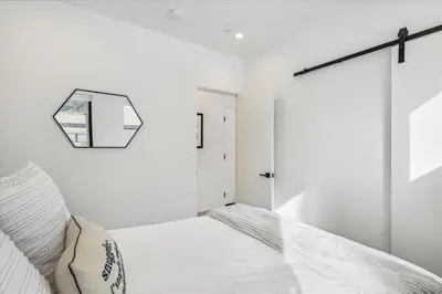 a white bedroom with a bed and a mirror at Diamond Run at Palisades - Luxury Townhome, Ski Shuttle Pet Friendly and Hot Tub! in Olympic Valley