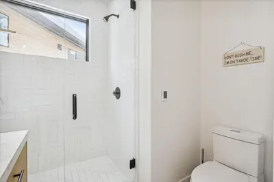 a white bathroom with a shower and a toilet at Diamond Run at Palisades - Luxury Townhome, Ski Shuttle Pet Friendly and Hot Tub! in Olympic Valley