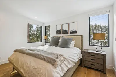 a white bedroom with a bed and two windows at Diamond Run at Palisades - Luxury Townhome, Ski Shuttle Pet Friendly and Hot Tub! in Olympic Valley