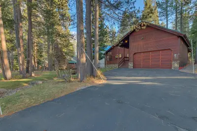 a house with a garage and a driveway at Dogwood Place by Tahoe Getaways - 3BR Pet-Friendly Tahoe Donner Home w Hot Tub, Pool Table, Wood Fireplace & HOA Amenities in Truckee