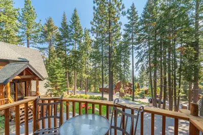 a deck with two chairs and a table at Ember Ridge Retreat by Tahoe Getaways - 3BR Pet-Friendly Carnelian Bay Rental w Fenced Yard, Ping Pong, Hot Tub, Near Northstar in Carnelian Bay