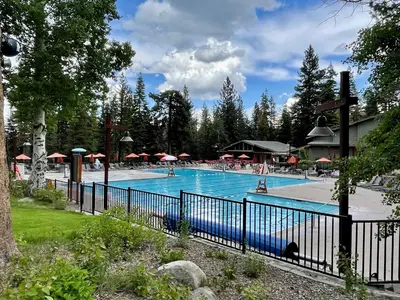 a large swimming pool with a blue fence at Fireside Lodge at Northstar By Tahoe Getaways - 4BR w Hot Tub, HOA & Ski Shuttle in Truckee