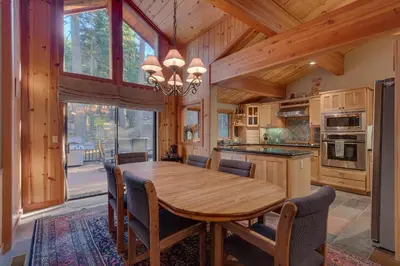 a large kitchen with a wooden table and chairs at Fireside Lodge at Northstar By Tahoe Getaways - 4BR w Hot Tub, HOA & Ski Shuttle in Truckee