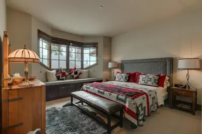 a bedroom with a bed with a bench and a window at Gondola Getaway- Ski-in Ski-out - Luxury 4 BR, Private Hot Tub, HOA Amenities in Truckee