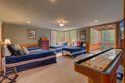 a room with two beds and a pool table at High Country Lodge by Tahoe Getaways - Tahoe Donner 4BR w Hot Tub, Air Conditioning, EV, HOA, Shuffleboard and Horse Shoe Pit in Truckee