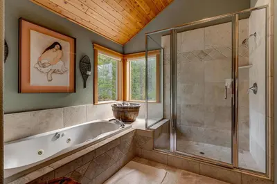a bathroom with a tub and a glass shower at High Country Lodge by Tahoe Getaways - Tahoe Donner 4BR w Hot Tub, Air Conditioning, EV, HOA, Shuffleboard and Horse Shoe Pit in Truckee
