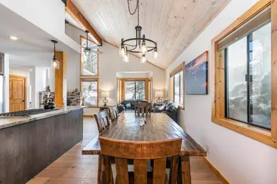 a kitchen and dining room with a wooden table and chairs at Kokanee at Tahoe Donner - Charming 3 BR - Pool Table - Fireplace - Amenity Access! in Truckee