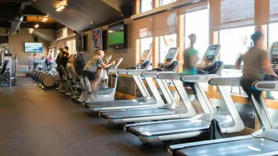 a gym with rows of treadmills and people on bikes at Kokanee at Tahoe Donner - Charming 3 BR - Pool Table - Fireplace - Amenity Access! in Truckee