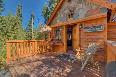a cabin with a deck and a chair on a porch at Lazy Bear in Tahoe City